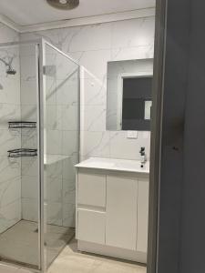 baño blanco con ducha y lavamanos en F.A convenient and livable place for daily life日常生活便捷宜居的地方 en Melbourne