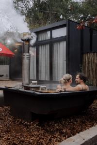 um homem e uma mulher sentados numa banheira em TWO Prefab Living - Luxury bungalows em Dullstroom