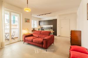 a living room with a red couch and a table at Wanderlust Experience Mood Apartment in Bitonto +20 photos