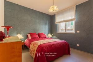 a bedroom with a red bed and a desk and a window at Wanderlust Experience Mood Apartment in Bitonto