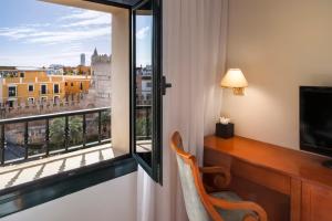 um quarto com uma secretária e uma janela com vista em Exe Sevilla Macarena em Sevilha