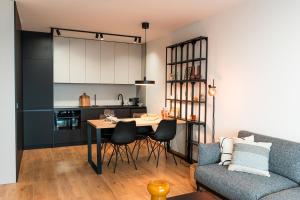eine Küche und ein Wohnzimmer mit einem Tisch und einem Sofa in der Unterkunft Luxury city center apartment - parking included in Košice