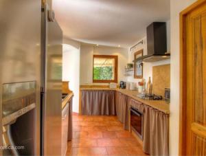 une cuisine avec un réfrigérateur en acier inoxydable dans l'établissement Gianni Location Palombaggia, à Porto-Vecchio