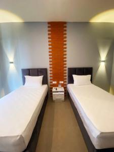 two beds sitting next to each other in a room at Swiss-Belexpress Rest Area KM 164, Cipali in Majalengka