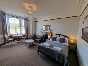 1 dormitorio con 1 cama, mesa y sillas en Carradale Guest House, en Lerwick