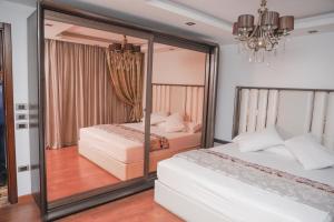 1 Schlafzimmer mit 2 Betten und einem großen Spiegel in der Unterkunft Platinum One Story Villa , 350 m , Heliopolis in Kairo