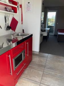 a kitchen with red cabinets and a sink at Hotel Gasthof Handewitt in Handewitt