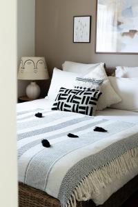 a bedroom with a white bed with black and white pillows at Casa Idalia Boutique Hotel in Comporta