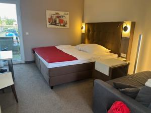 a hotel room with a bed and a couch at Hotel Gasthof Handewitt in Handewitt