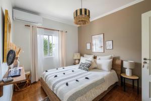 a bedroom with a large bed and a window at Casa Idalia Boutique Hotel in Comporta