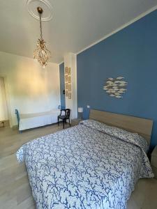 1 dormitorio con cama y pared azul en Una finestra sul Mare, en Laigueglia