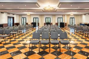 a conference room with chairs and a stage in the center at Exe Sevilla Macarena in Seville