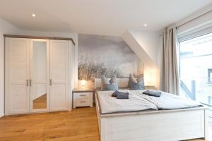 - une chambre avec un lit blanc et une grande fenêtre dans l'établissement SEENsucht - b47541, à Malchow