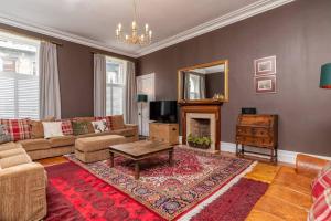 uma sala de estar com um sofá e uma lareira em 6 Howard Place em St. Andrews