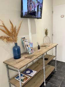 a wooden table with a television on a wall at Studi'o Lubéron in Cavaillon