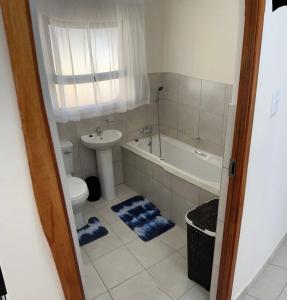 uma casa de banho com um WC, um lavatório e uma banheira em MV self-catering Linden em Bloemfontein