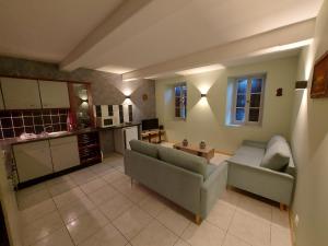 a living room with two couches and a kitchen at Lahitte in Saint-Frajou
