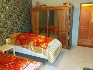 a bedroom with a bed and a wooden cabinet at Lahitte in Saint-Frajou
