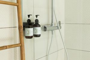 two bottles of wine hanging on a wall in a shower at Casa Idalia Boutique Hotel in Comporta