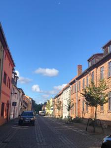 une rue avec une voiture garée dans une rue pavée dans l'établissement SEENsucht - b47541, à Malchow