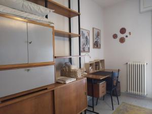 ソンドリオにあるLa Casina Sondrio Valtellinaのデスクと大きな木製キャビネットが備わる客室です。