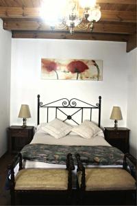 a bedroom with a bed and two lamps and a chandelier at La Calleja Real in Liérganes