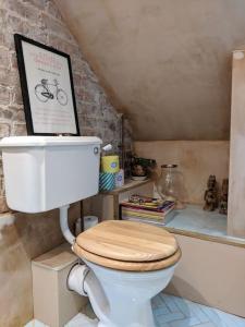 a bathroom with a toilet with a picture on top of it at Stylish 1 bed with large plant filled garden in London