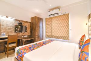 FabHotel Prime The Pavilion في kolkata: غرفة نوم بسرير ومكتب في غرفة