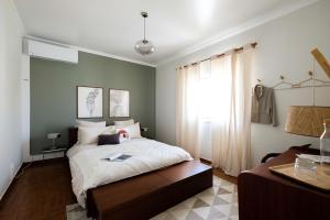 a bedroom with a large bed and a window at Casa Idalia Boutique Hotel in Comporta