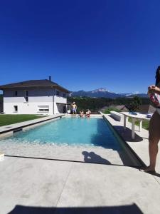 una mujer parada junto a una piscina en villa florian et vally, en Charvonnex