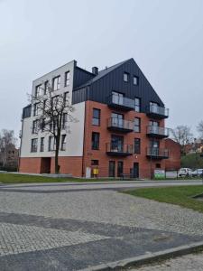 um grande edifício de tijolos com um telhado preto em Apartament Nad Wisłą u Ani em Tczew