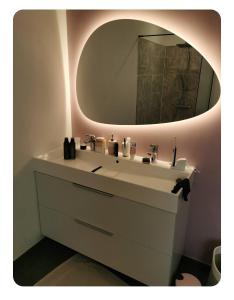 y baño con lavabo blanco y espejo. en villa florian et vally, en Charvonnex