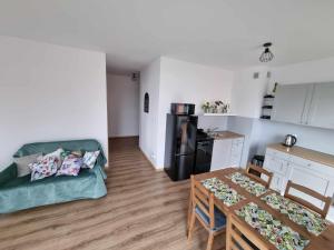 a living room with a table and a kitchen with a dining room at Apartament Nad Wisłą u Ani in Tczew