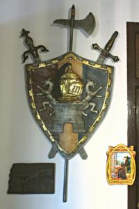 un bouclier avec une croix et deux épées sur un mur dans l'établissement La Calleja Real, à Liérganes