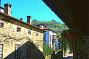 a group of buildings with a mountain in the background at La Calleja Real in Liérganes