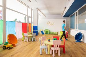 una habitación con una mesa y sillas y una persona caminando en htop Platja Park #htopFun, en Platja d'Aro