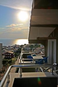 a balcony with blue chairs and the ocean at Apartments MileS in Utjeha