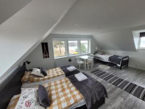 um quarto no sótão com 2 camas e uma mesa em Restaurang Sjövik em Motala