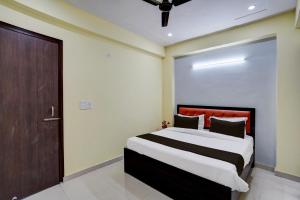 a bedroom with a large bed and a brown door at OYO YUVRAJ RESIDENCY in Noida