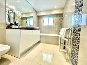 un bagno bianco con lavandino e WC di Bel appartement Centre ville, mer, Croisette a Cannes Altre 13 foto