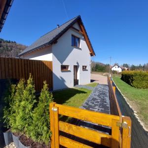 una casa bianca dietro una recinzione di legno di Na Kamieńcu domki a Rzyki