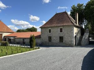 an old stone building on a road at Château de la Mothe - Gîte Hugues de PAYNS in Vicq