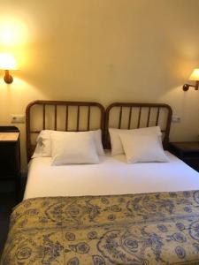een slaapkamer met een bed met 2 kussens bij Hotel Xalet la Coromina in Viladrau