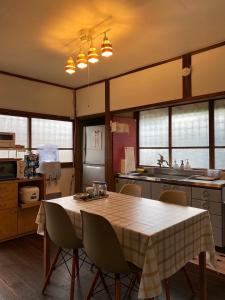 a kitchen with a table and chairs in it at 農家古民家ねこざえもん奥屋敷 Nekozaemon-Gest house in Nishiwada