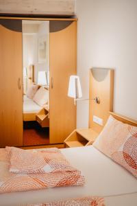 een slaapkamer met 2 bedden en een spiegel bij Hotel Garni Stube in Königschaffhausen