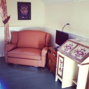 a living room with a chair and a desk with a computer at Hotel Xalet la Coromina in Viladrau