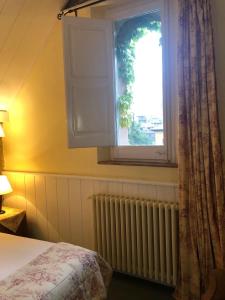 um quarto com uma cama, uma janela e um radiador em Hotel Xalet la Coromina em Viladrau