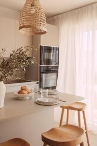 uma cozinha com um balcão com 2 bancos e um micro-ondas em Soleil Riviera Apartament Côte d’Azur em Roquebrune-Cap-Martin