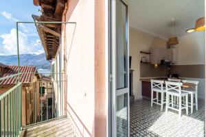 einen Balkon mit Blick auf eine Küche und die Berge in der Unterkunft Lotus Apartment by Wonderful Italy in Bellagio