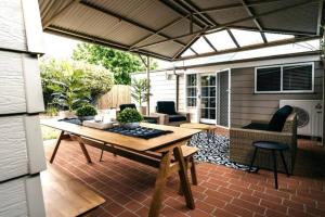 a patio with a wooden table and chairs at The Icely Cottage in Orange
